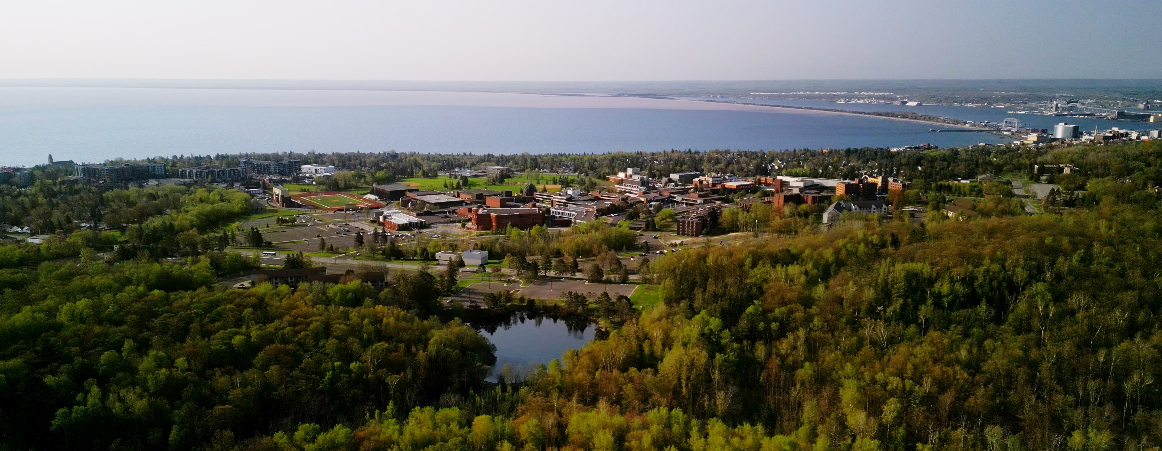 A summer aerial view of campus, facing Lake Superior